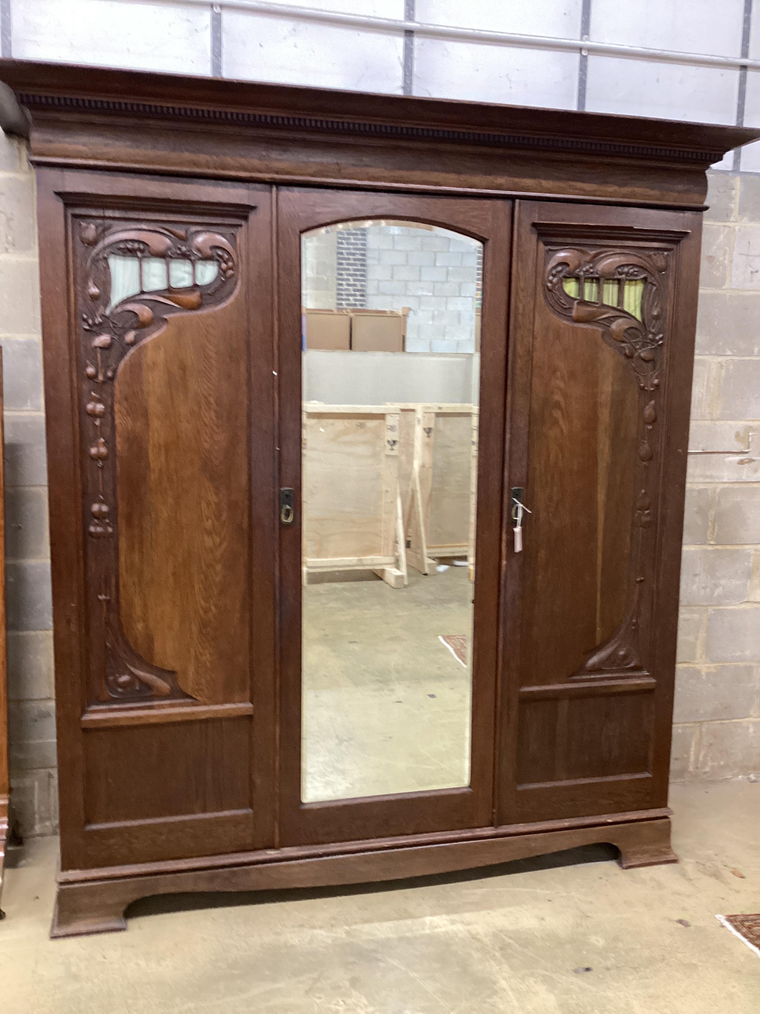 A late 19th century French Art Nouveau carved oak compactum wardrobe, width 205cm, depth 64cm, height 218cm